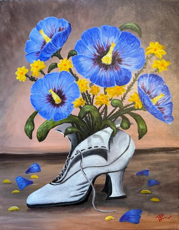 Blue flowers and yellow blossoms in a white Victorian lace-up boot, with petals scattered around it