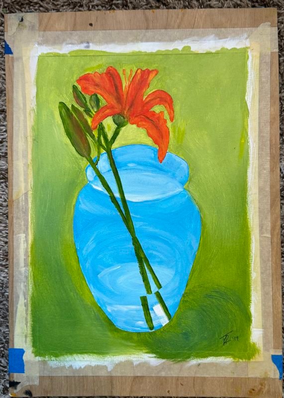 Orange lily stems in a light blue vase on a green background