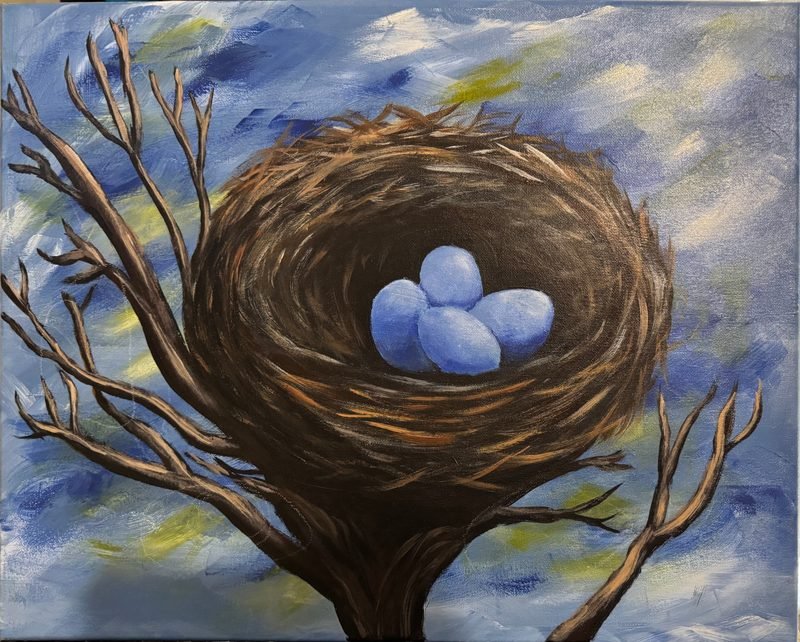 Bird's nest holding three blue eggs in bare branches against a cloudy blue sky